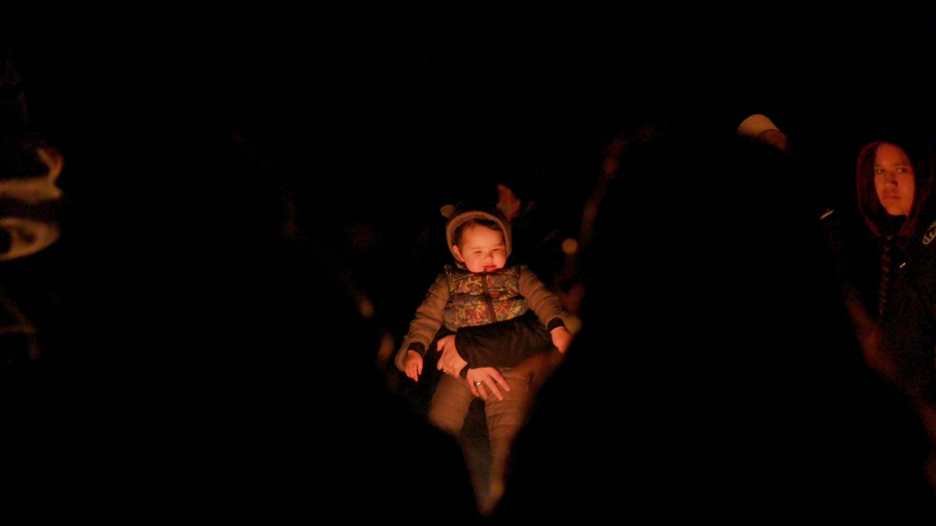 Mother with her pēpē by the fire in Pikirangi Village